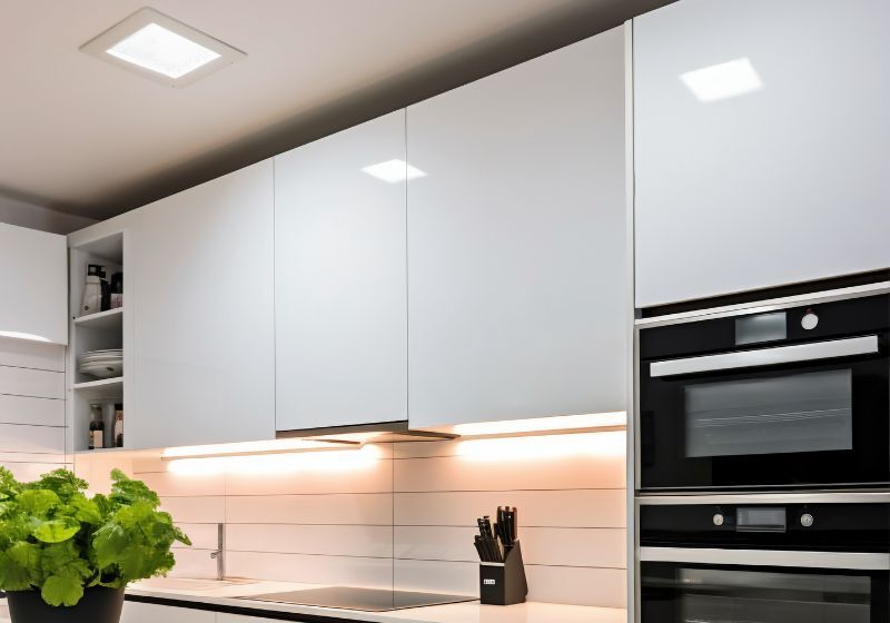 Cozinha moderna com armários brancos e iluminação suave