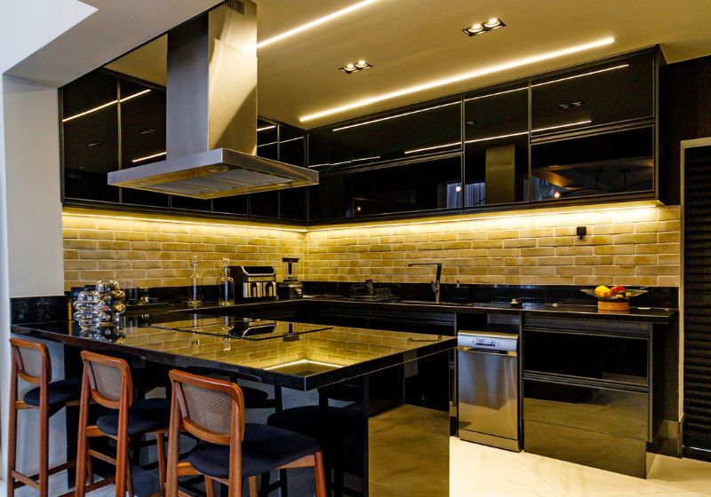 Cozinha moderna com decoração preta e iluminação suave.