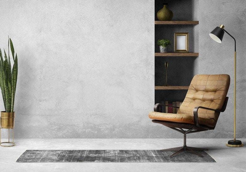 Imagem de uma sala de estar com abajur, cadeira e vaso de planta