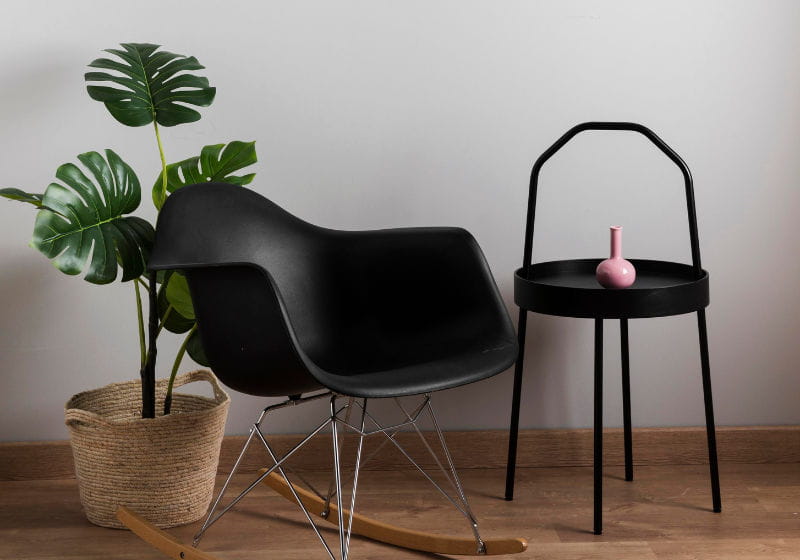 cadeira preta contemporânea com planta e mesa lateral