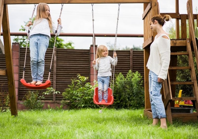 crianças brincando em um balanço no jardim