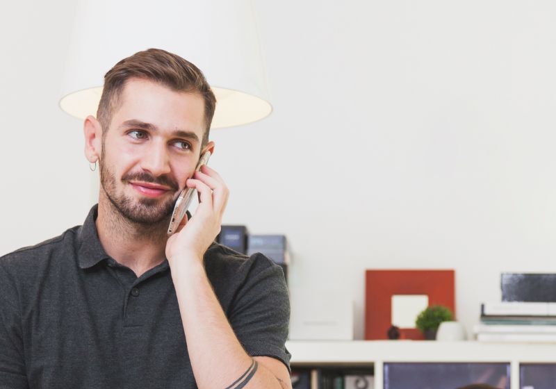 Homem conversando ao telefone em ambiente moderno.