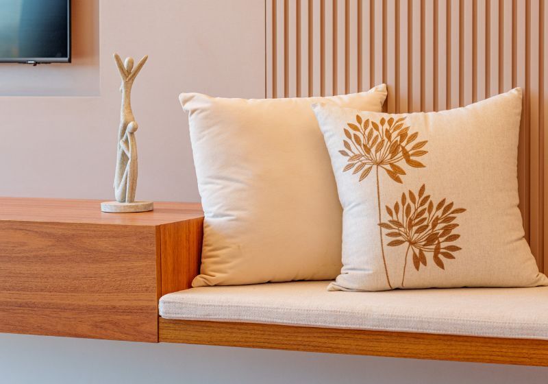 Canto de sala com almofadas e escultura decorativa