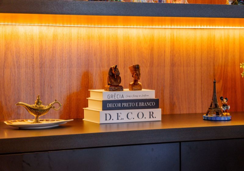 Decoração moderna com livros e estatuetas na prateleira.