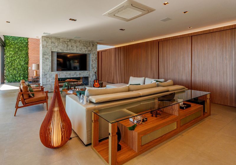 Sala moderna com sofá, mesa de vidro e decoração elegante.